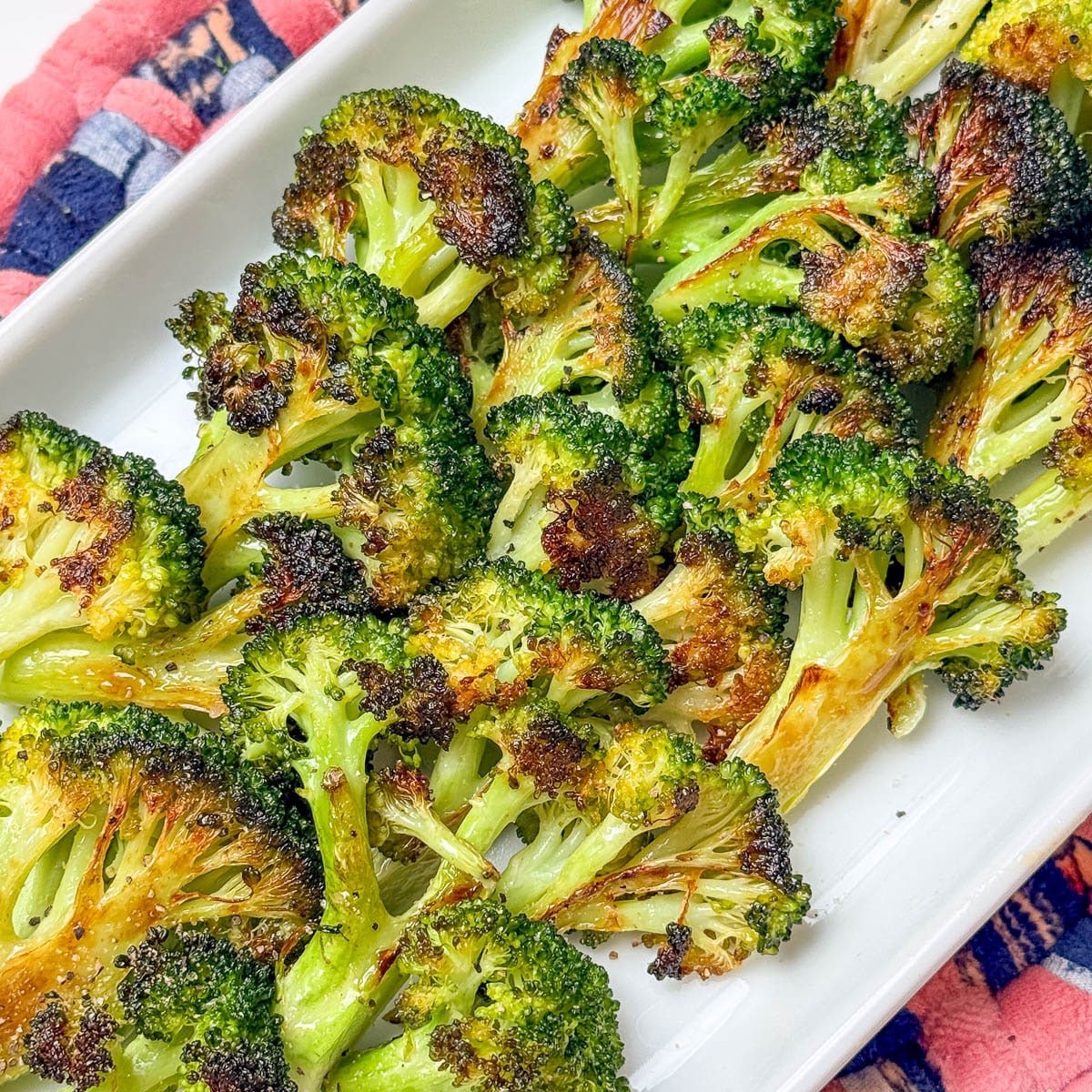 Oven roasted broccoli on a white platter.