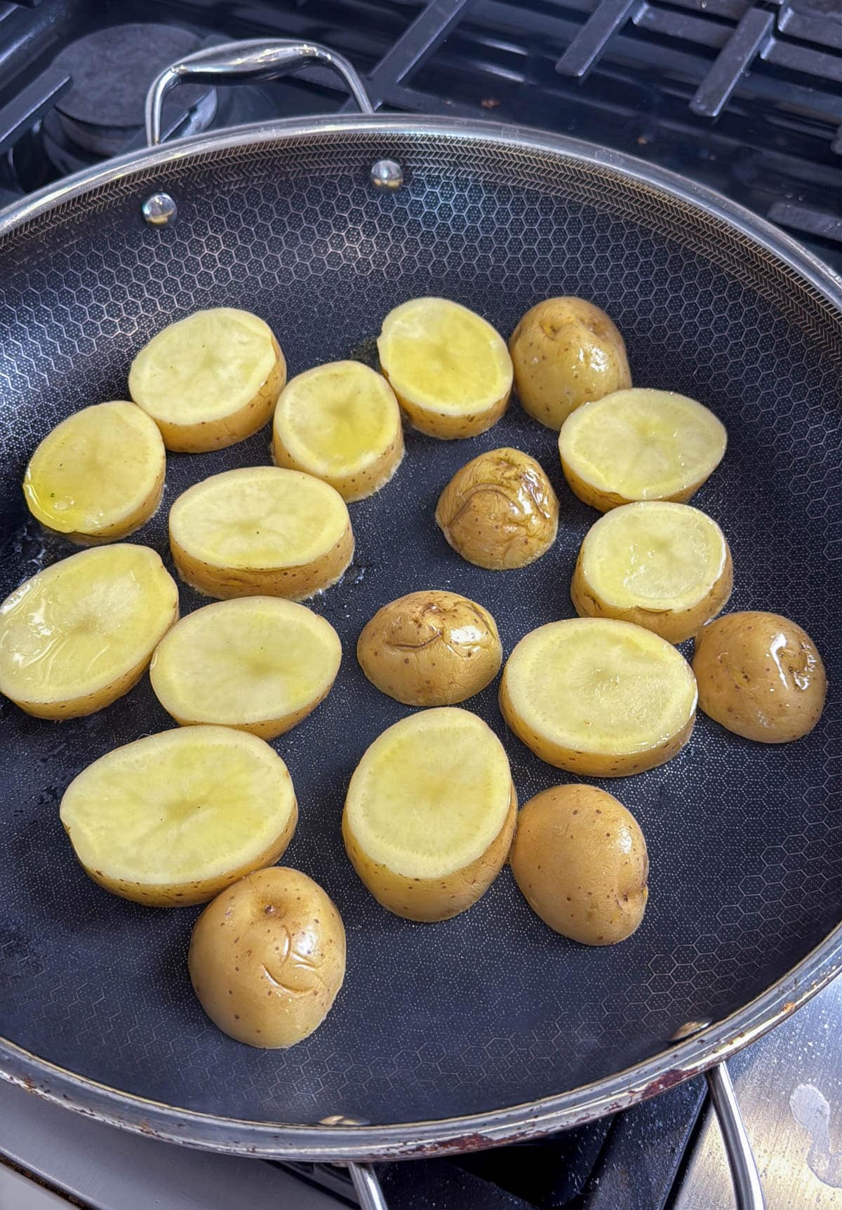 Potato slices in a large skillet.