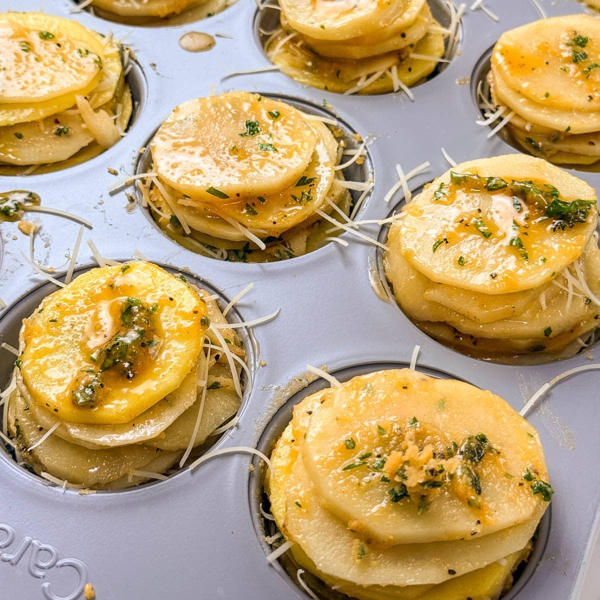 Thinly sliced layers of potato stacks in a cupcake tin