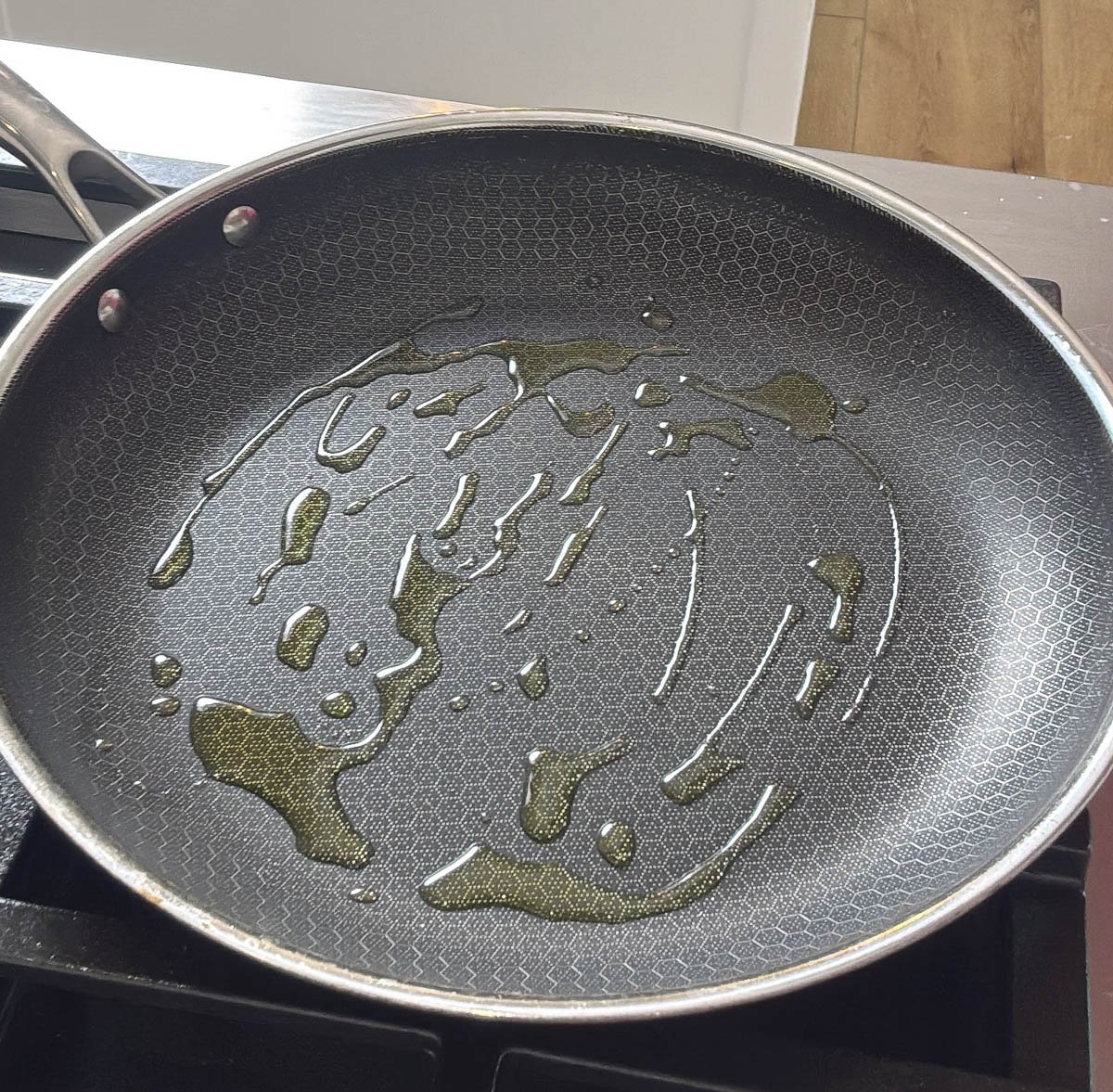 A HexClad skillet with oil in it.