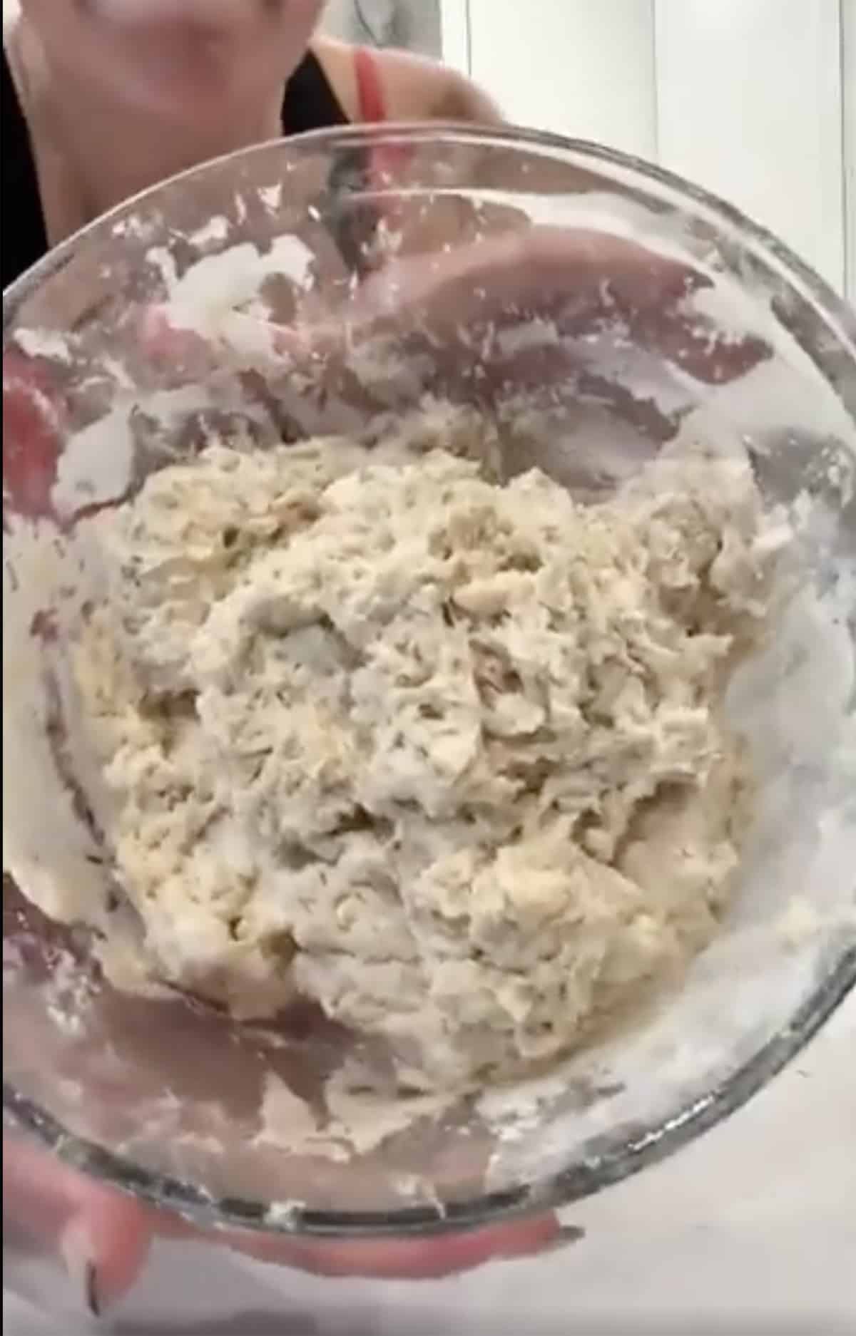 Rough dough in a clear glass bowl.