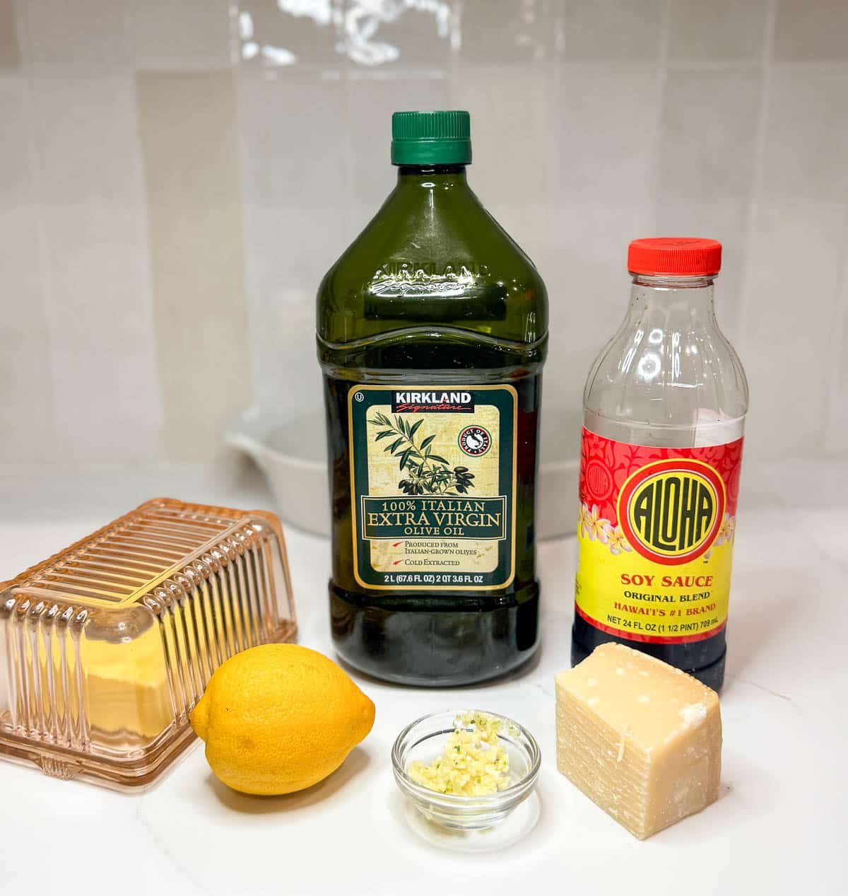 Ingredients to make broccoli taste better: extra-virgin olive oil, soy sauce, butter, lemon, garlic, and parmesan cheese.