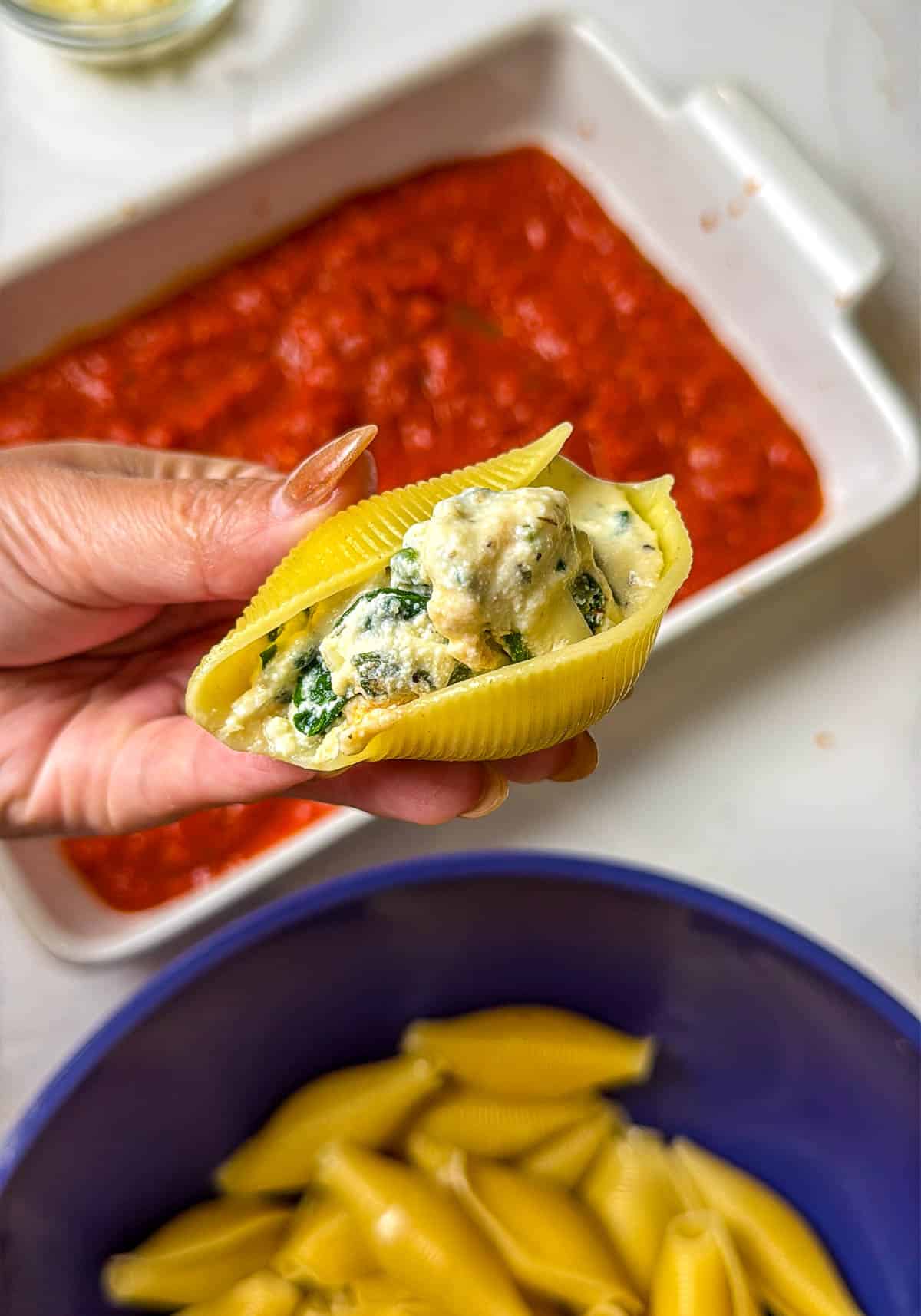 A close-up photo of a pasta shell filled with the ricotta mixture.