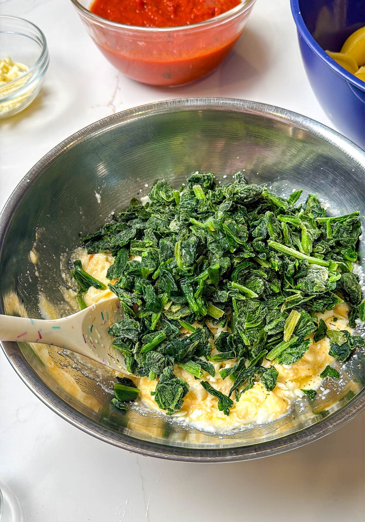 Frozen spinach added to the cheese mixture.