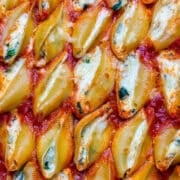 close up of stuffed shells in marinara sauce