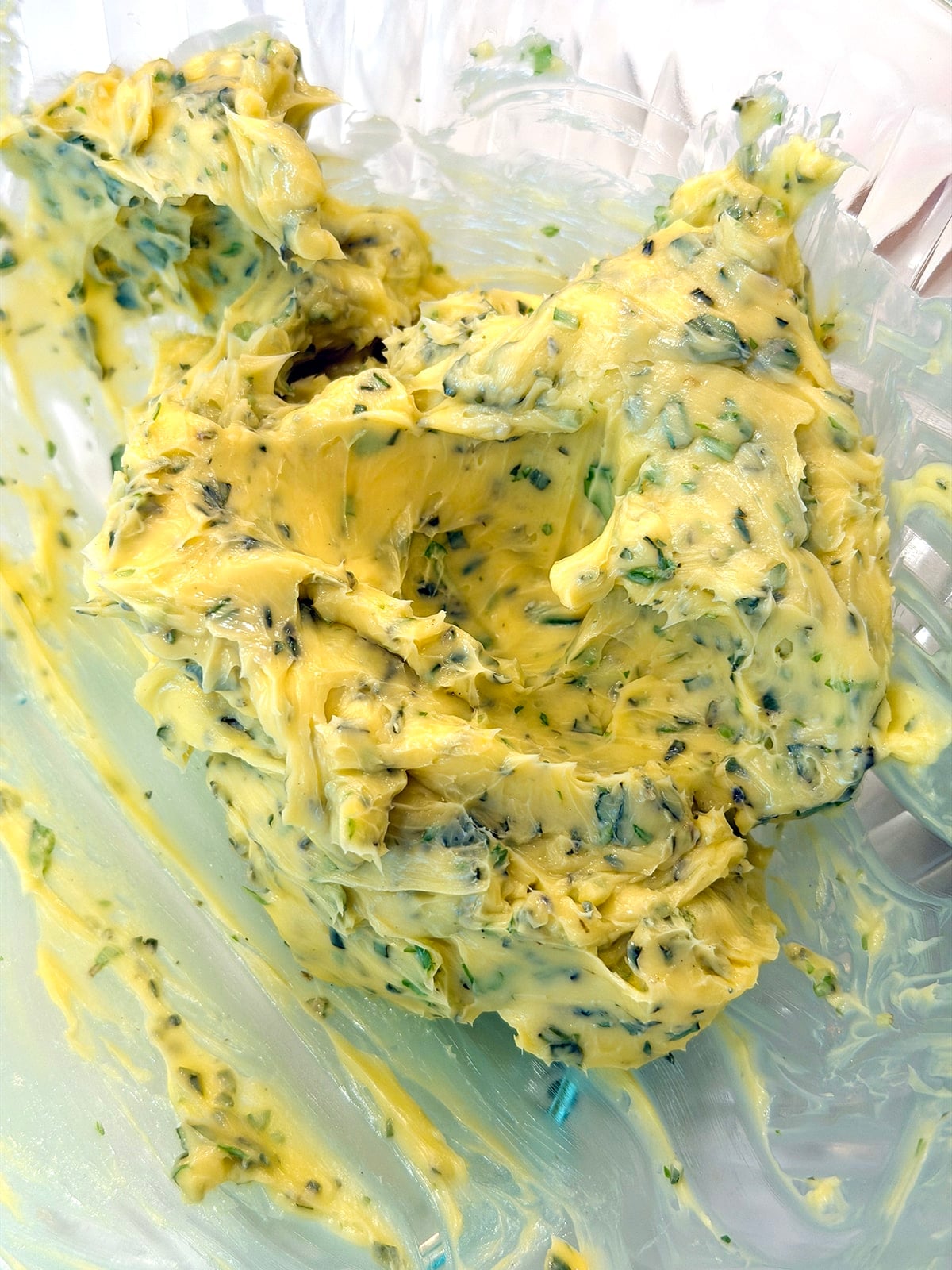Close up of compound butter with fresh chopped herbs.