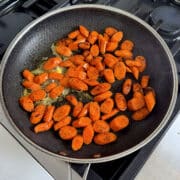 close up of carrots sauteeing in a large pan