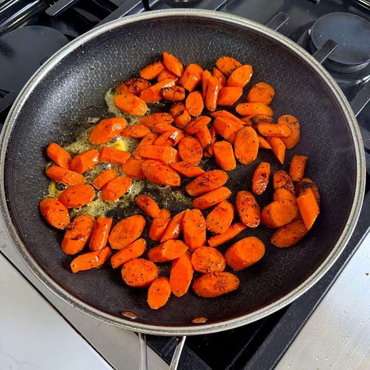 close up of carrots sauteeing in a large pan