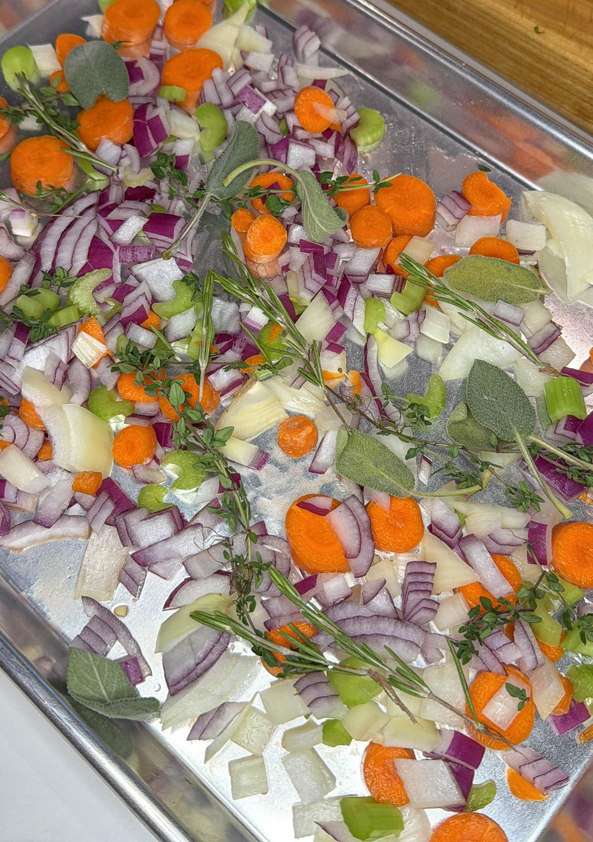Vegetables and herbs on a baking sheet.