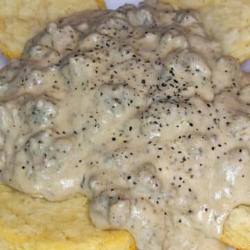 close up of sausage gravy on biscuits