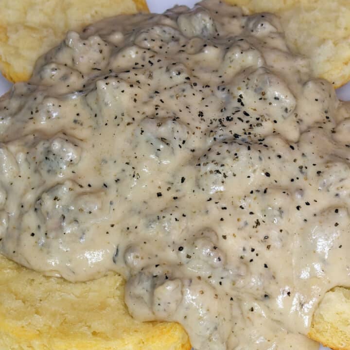 close up of sausage gravy on biscuits