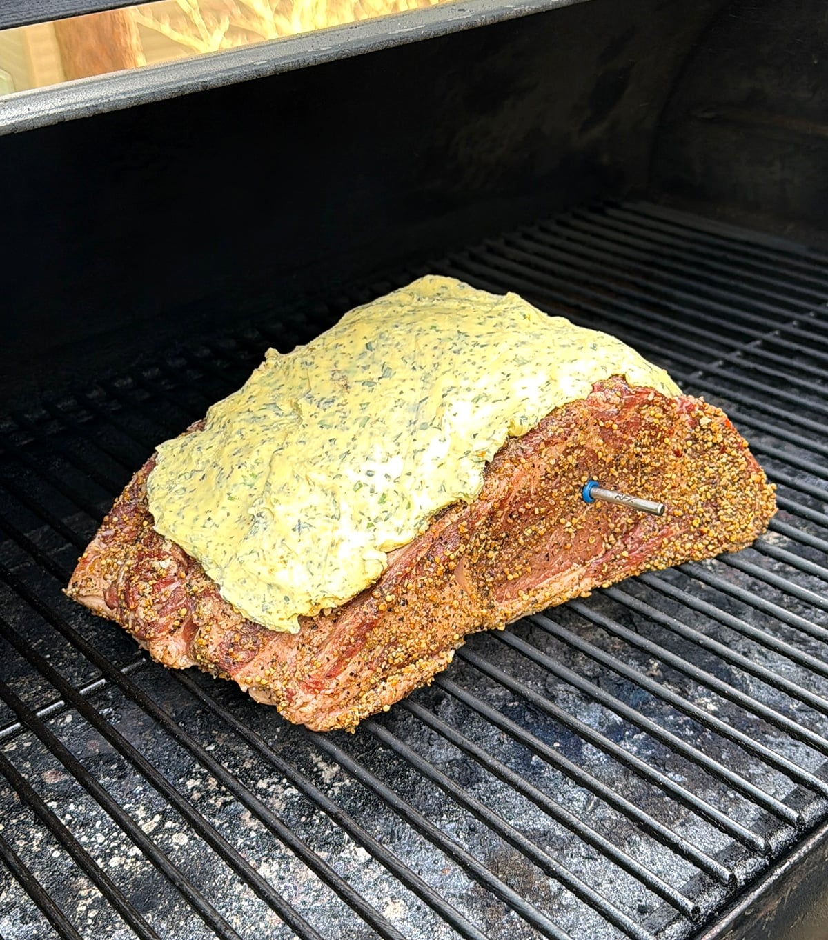 Prepared prime rib roast on a hot smoker grill.
