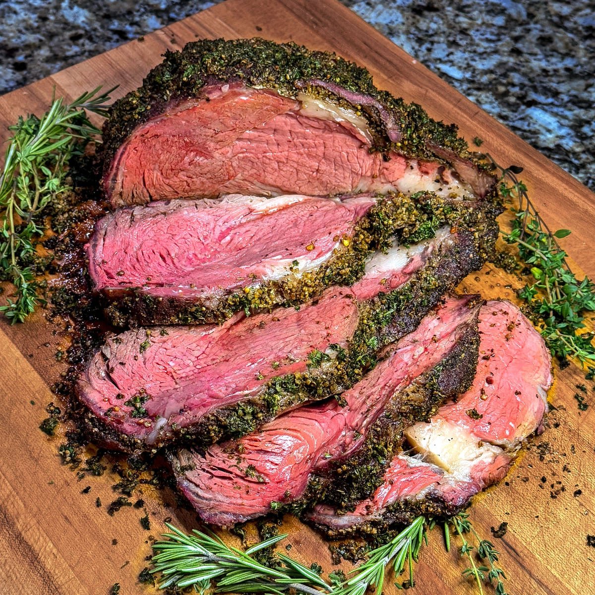 A close-up photo of a sliced, smoked prime rib on a wooden cutting board.