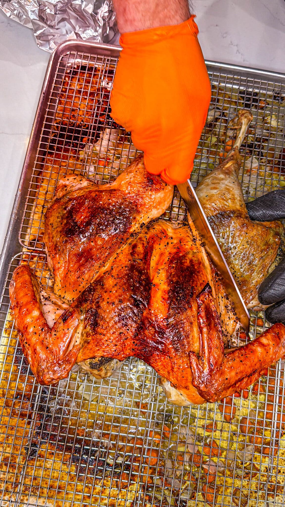 Roasted spatchcocked turkey being carved.