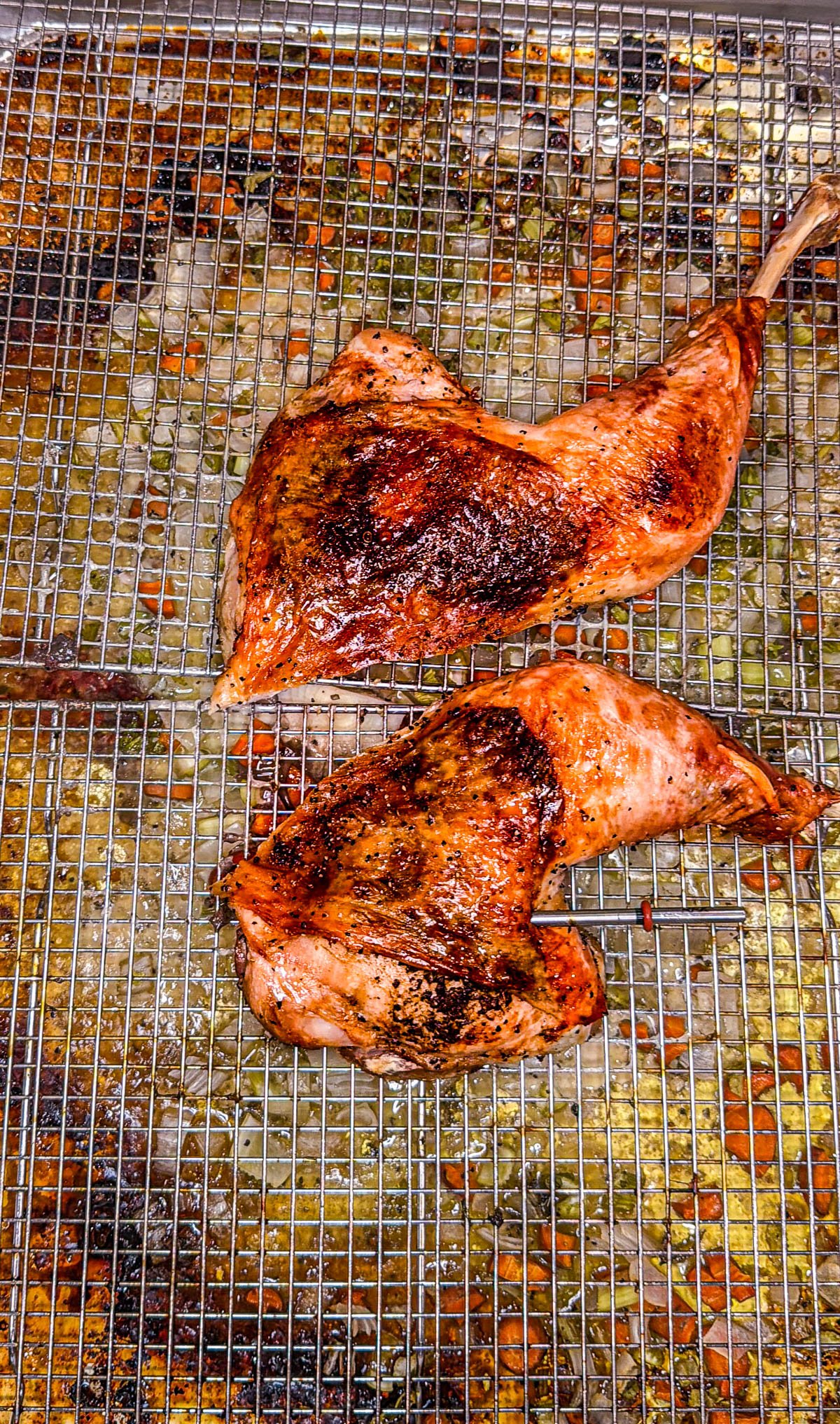 Roasted spatchcocked turkey legs on a wire rack.