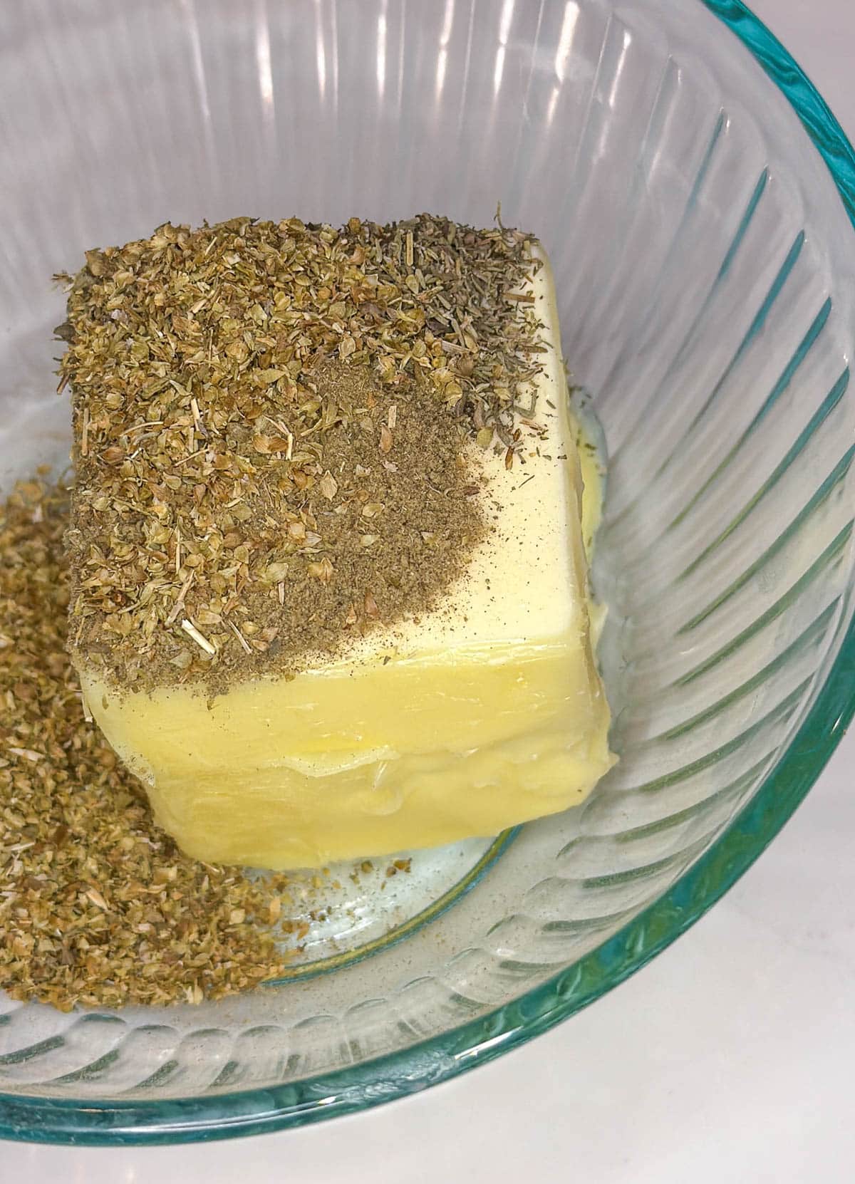 Softened butter and seasoning in a small bowl.