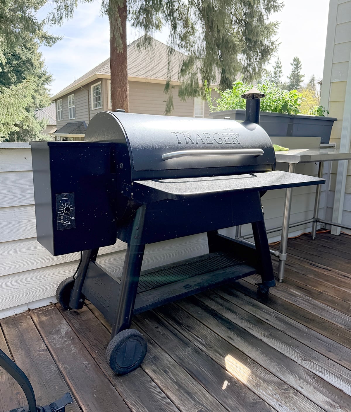 Photo of a Traeger pellet grill outside on a wooden deck.