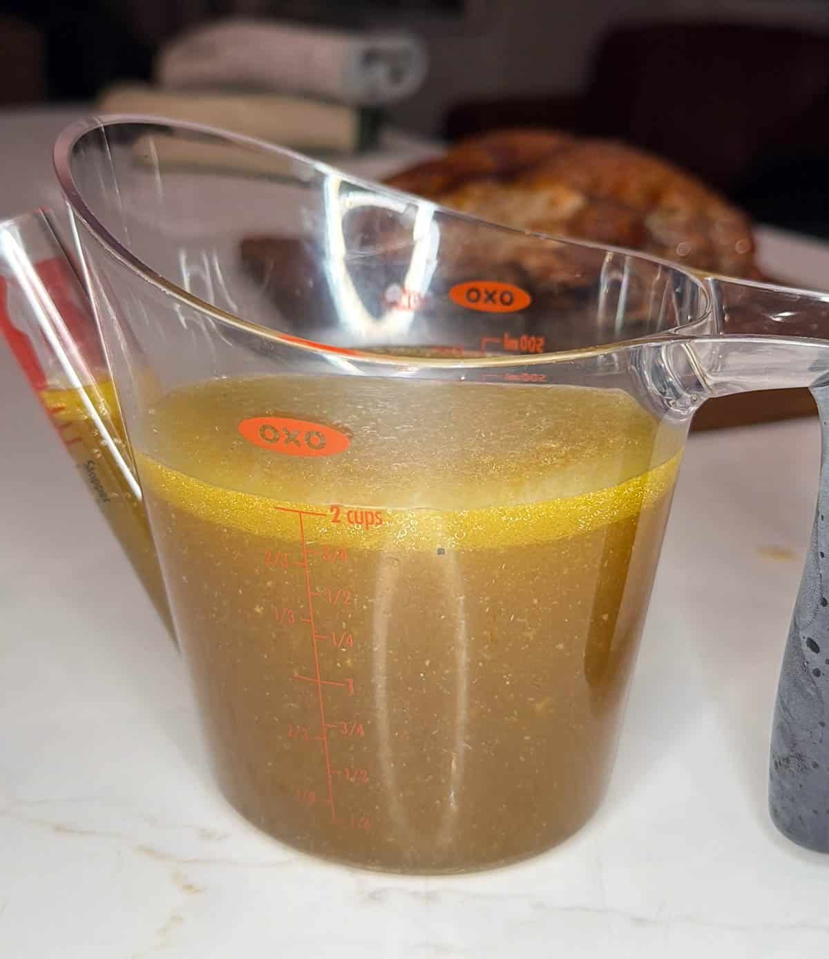 Turkey broth in a small measuring cup.