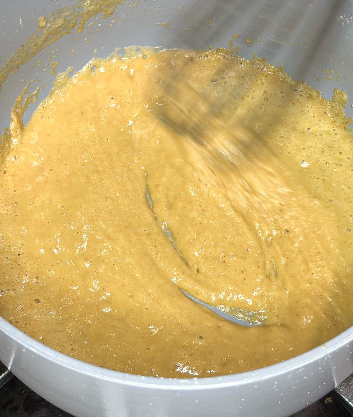 Flour is added to the brown butter and whisked in to make a roux.