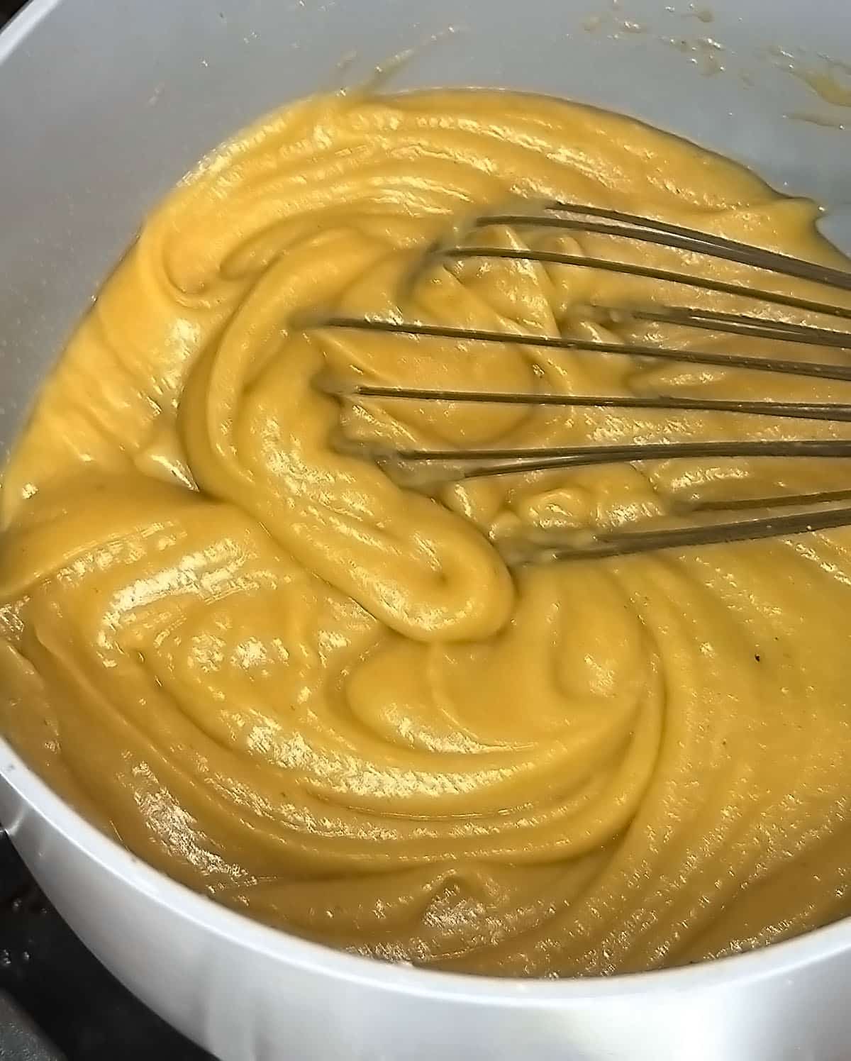 Roux continues to cook while whisked and thickened.