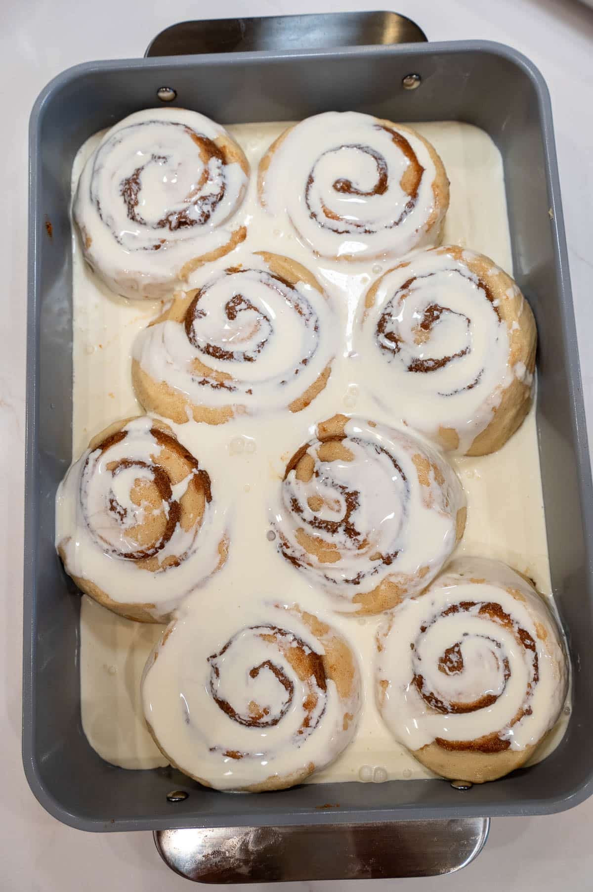 Sourdough cinnamon rolls portioned into a pan covered in heavy cream.