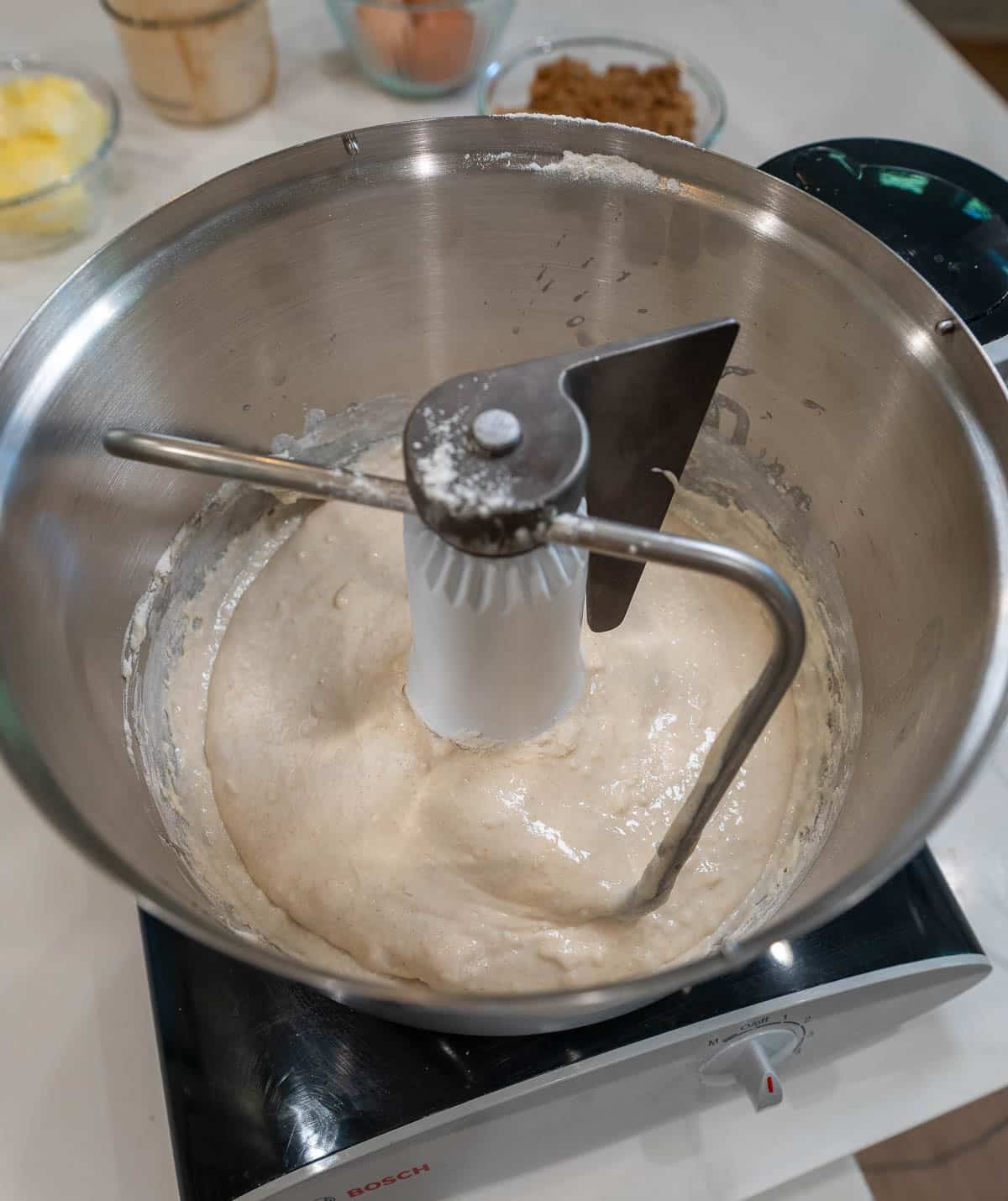 Sourdough discard cinnamon roll dough in a stand mixer with the dough hook attached.