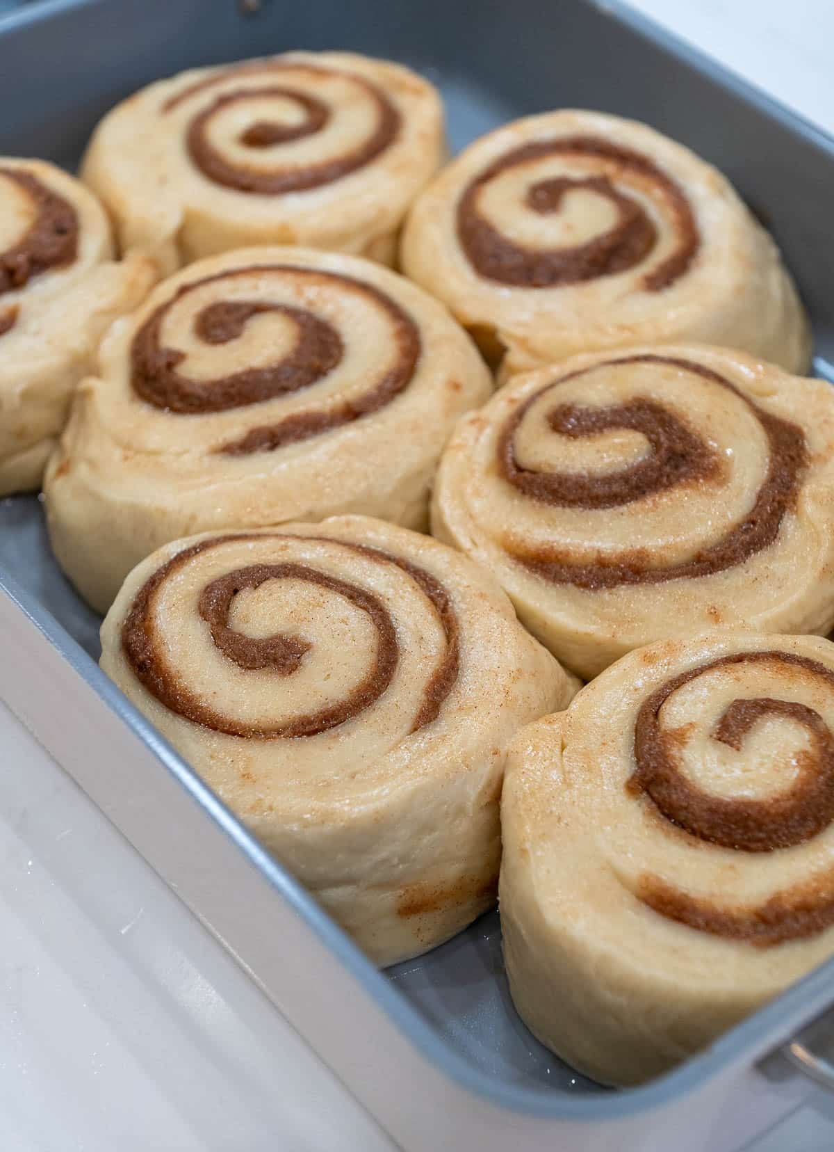 Sourdough cinnamon roll slices placed into a pan.