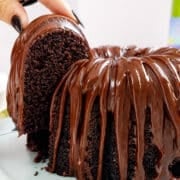 Slice of wine cake with chocolate drizzle on top.