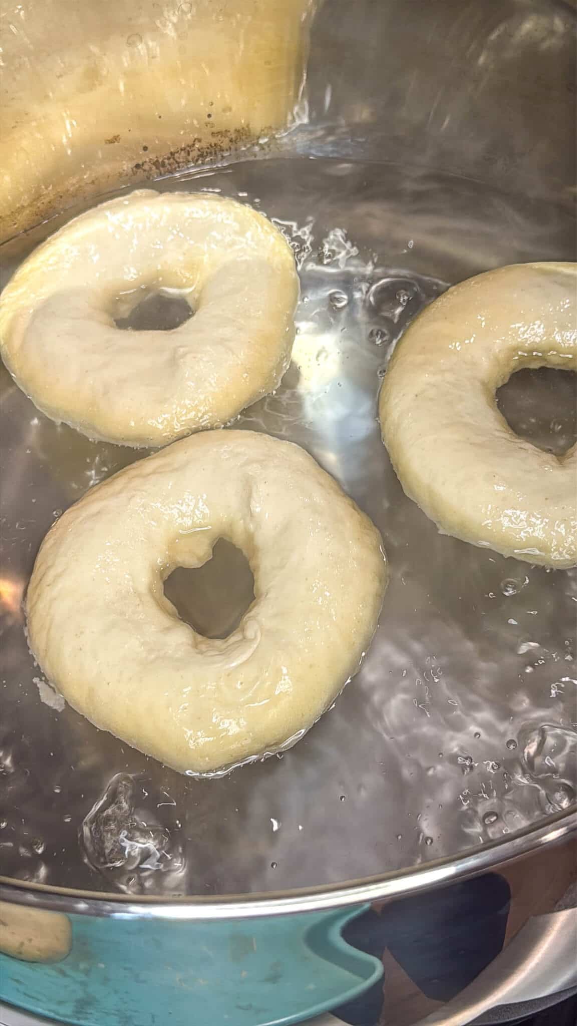 Sourdough discard bagels boiling in water.