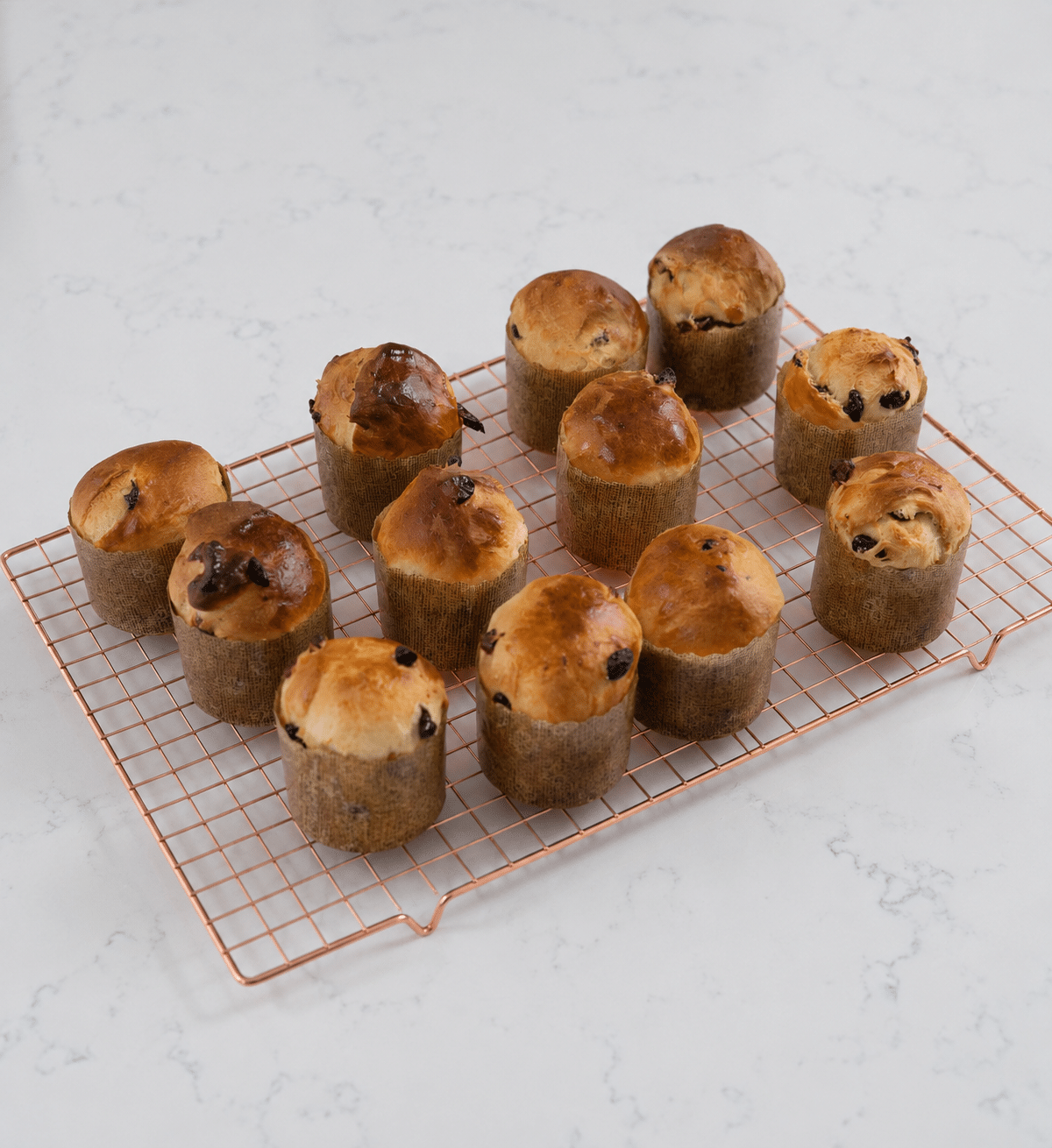 Mini panettone loafs cooling on a wire wrack.