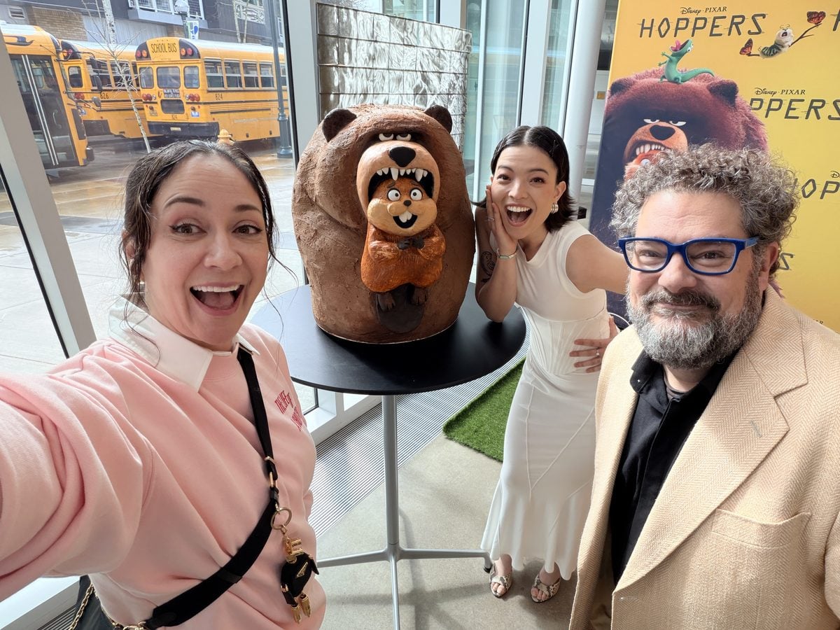 Liz Marek with the sculpted bear-and-beaver cake she made for the Disney and Pixar Hoppers premiere, posing with two of the film's stars