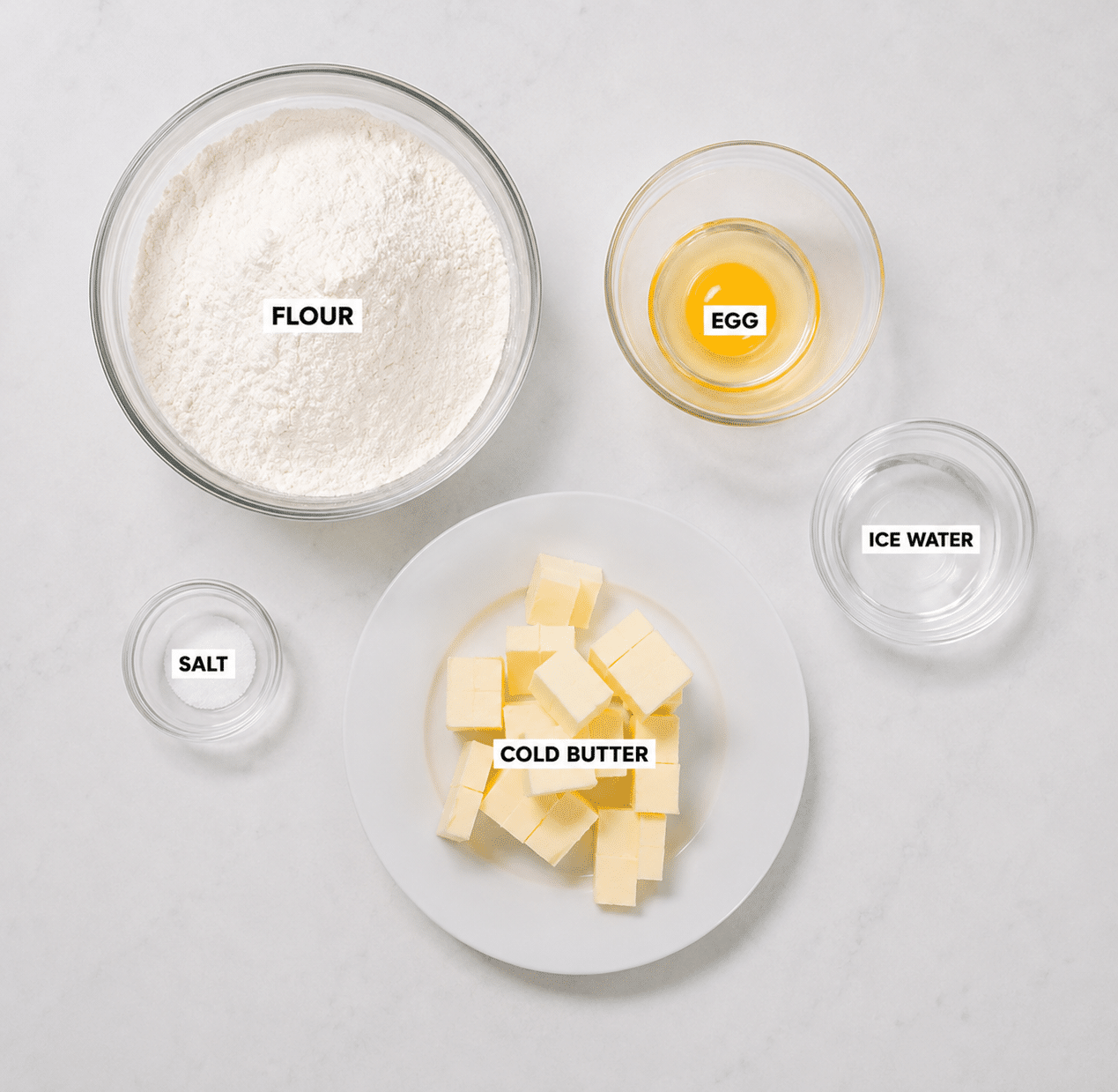 Mealy pie dough ingredients: all-purpose flour, ice water, salt, cold butter, and an egg.