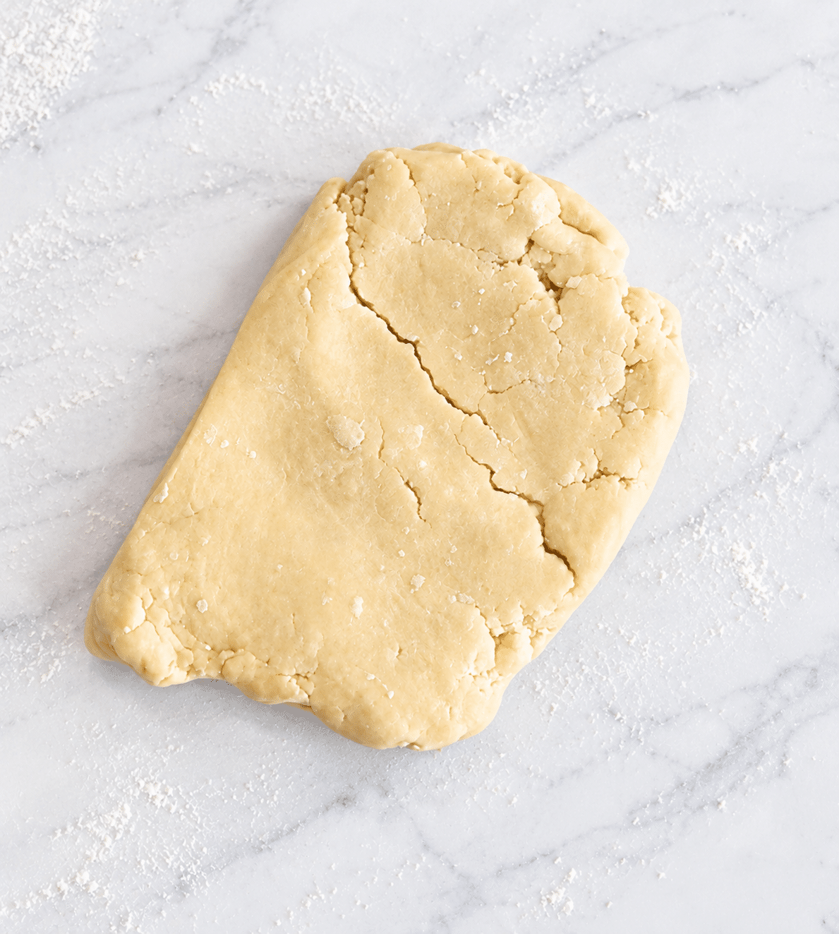 Pie dough resting on a countertop dusted with flour.