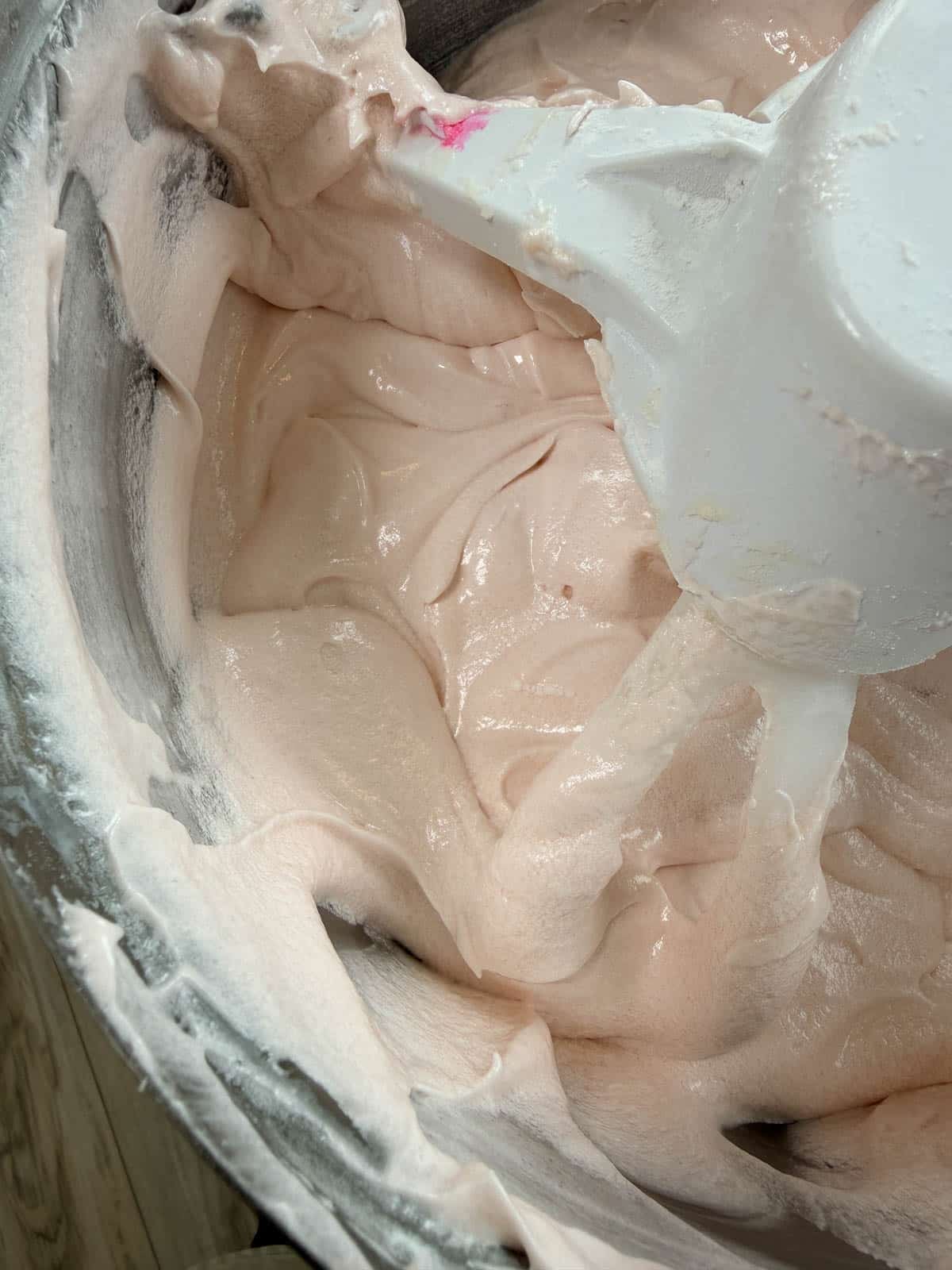 Close up of pink champagne cake batter in a stand mixer.