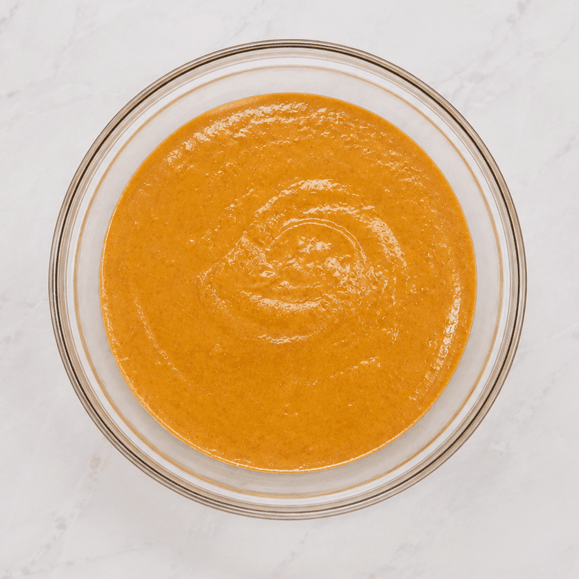 Fully combined pumpkin pie filling in a glass bowl.