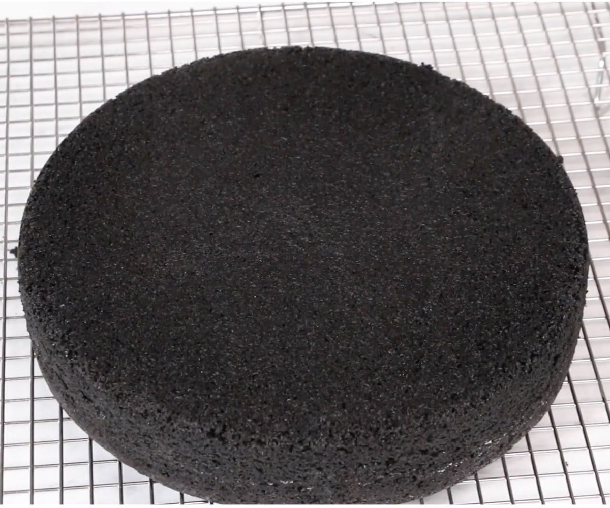 Black velvet cake layer cooling on a wire rack.