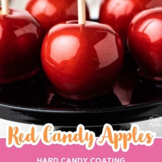Close-up of shiny red candy apples on a black cake stand