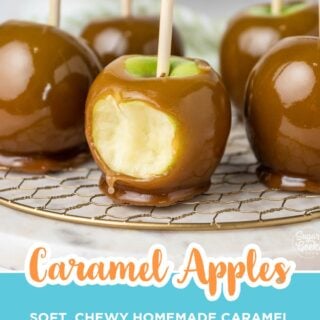 Homemade caramel apples on sticks with a bite taken out of one