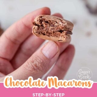 Hand holding a chocolate macaron with a bite taken out, Pinterest image.