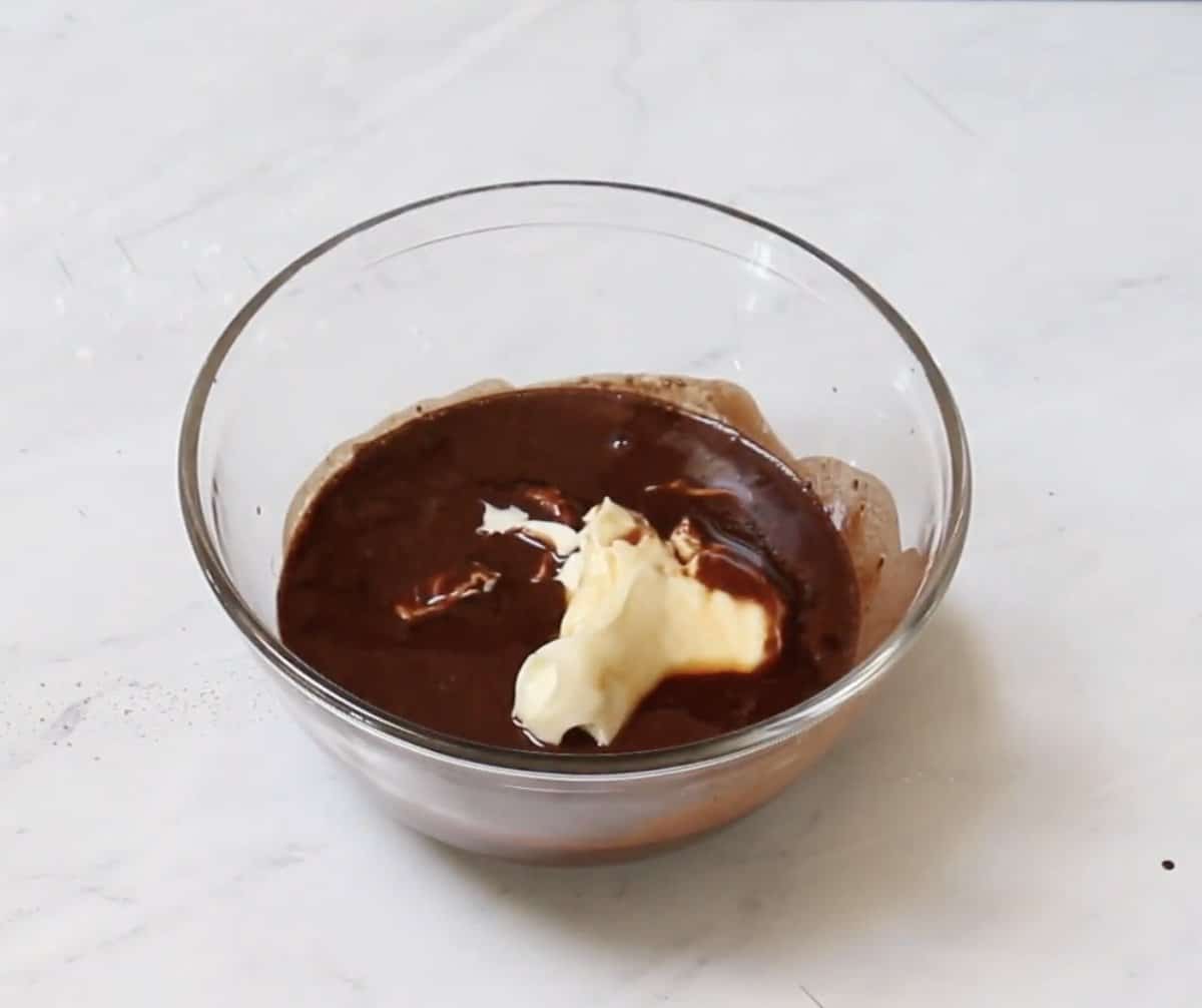 Mayonnaise added to the cocoa mixture in a glass bowl.
