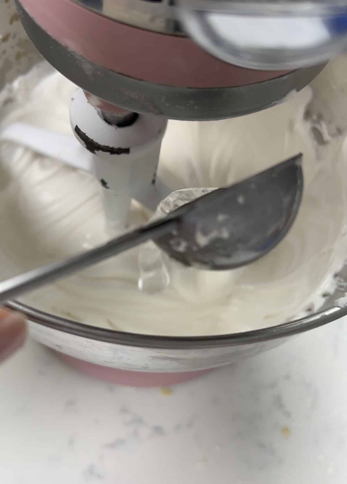 Adding water to royal icing with a spoon.