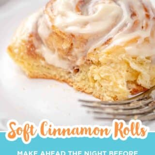 Soft cinnamon roll with cream cheese frosting cut open to show the fluffy inside