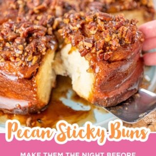 pulling apart a gooey caramel pecan sticky bun with a spatula